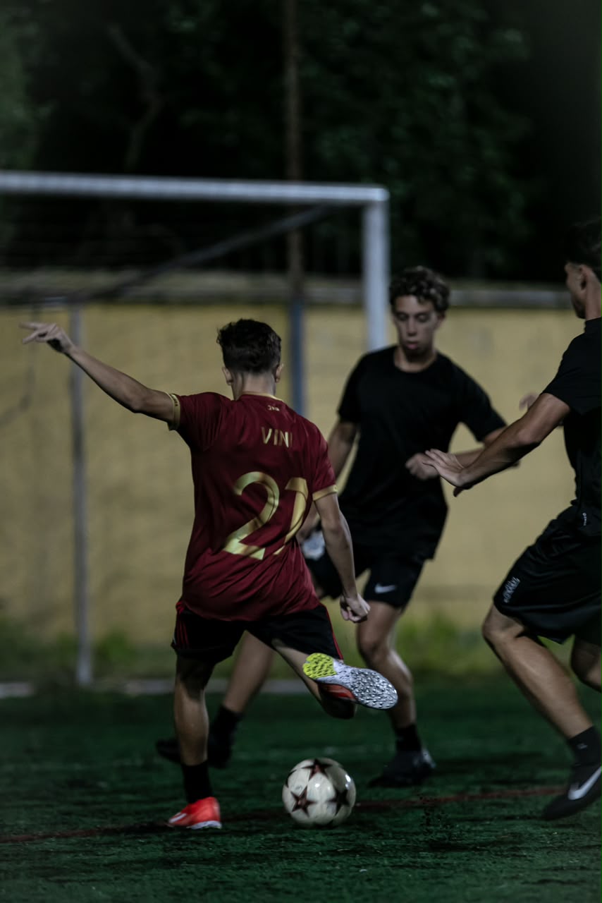 Jogador do Barkajara FC com camisa vinho número 27 chutando a bola